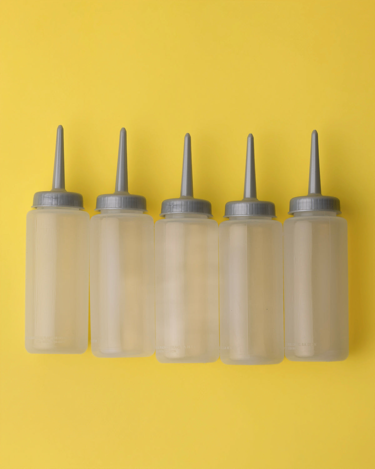 Paquete de Botes: five clear refillable squeeze bottles with gray nozzle caps